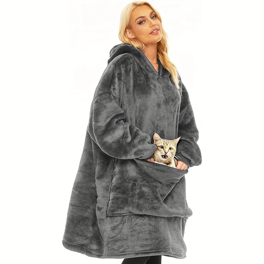 Soft comfortable large hooded blanket in black, warm and wearable for indoor use. Features an oversized fit with a spacious front pocket holding a cat.