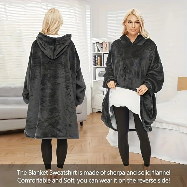 Soft comfortable large hooded blanket in black, warm and wearable for indoor use. Features an oversized fit with a spacious front pocket holding a cat.